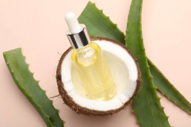 Saç tedavisi. Kozmetik ürün, hindistan cevizi ve aloe yaprakları bej arka planda, düz yatar