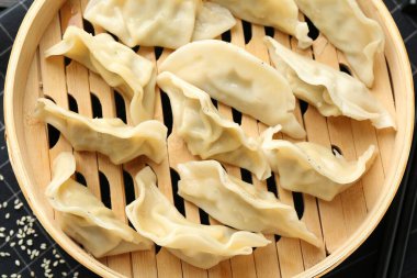 Lezzetli kaynamış gyoza (hamur tatlısı), masa üzerinde susam, üst görünüm