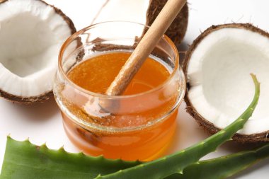Saç tedavisi. Hindistan cevizi, bal ve aloe yaprakları beyaz arka planda, yakın plan