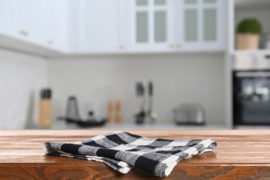 Mutfakta ahşap yüzey üzerindeki kareli masa örtüsü.