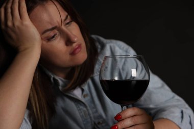 Alkol bağımlılığı. Karanlıkta şarap içen sefil kadın.