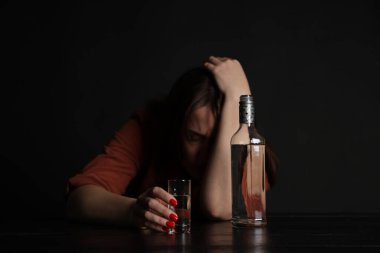 Alkol bağımlılığı. Masasında votka olan sefil bir kadın.