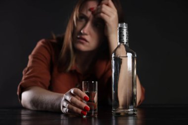 Alkol bağımlılığı. Masasında votka olan sefil bir kadın.