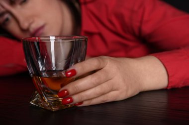 Alkol bağımlılığı. Masasında viski olan zavallı kadın. Karanlık, seçici bir odak noktası.