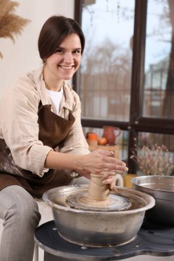 Hobi ve zanaat. Gülümseyen kadın içeride çömlek yapıyor.