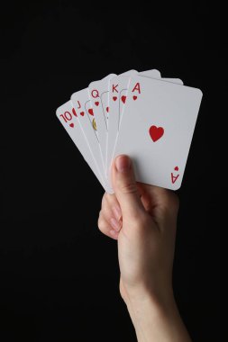 Siyah arkaplanda oyun kartları olan kadın, yakın plan