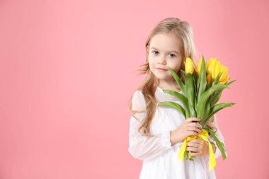 Pembe arka planda güzel sarı laleleri olan şirin küçük bir kız. Mesaj atmak için yeri var. Bahar mevsimi