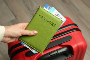 Pasaportu, biletleri ve bavulu olan kadın, yakın plan.