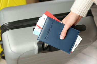 Pasaportlu kadın, biletler ve bavullar içeride, yakın plan.