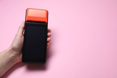 Pembe arka planda ödeme terminali olan kadın, yakın plan. Metin için boşluk