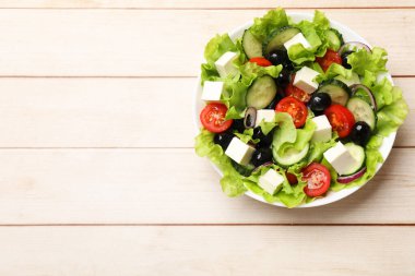 Hafif ahşap masada nefis taze Yunan salatası, üst manzara. Metin için boşluk