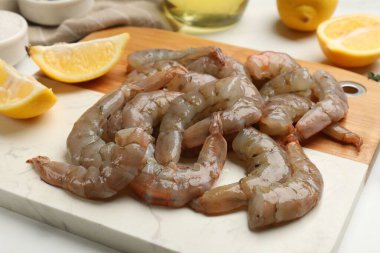 Taze çiğ karides ve beyaz masada limon dilimleri, yakın plan.