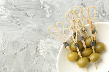 Gri dokuma masasında salamura edilmiş zeytinler, üst manzara. Metin için boşluk