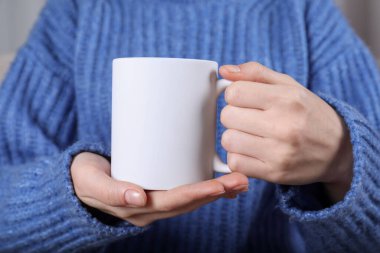 Elinde boş beyaz seramik bardak tutan kadın, yakın plan. Tasarım için model