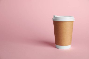 Pembe arka planda bir kağıt bardak. Tasarım için model