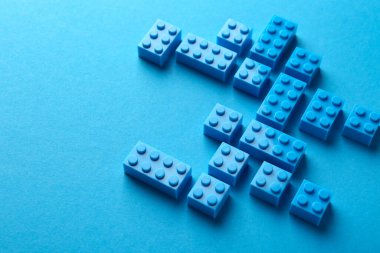 İnşaat oyuncağı. Açık mavi arkaplan üzerinde birçok yapı taşı, görünümün üzerinde