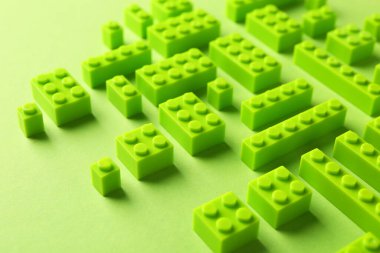 İnşaat oyuncağı. Açık yeşil arkaplanda birçok yapı taşı, yakın plan