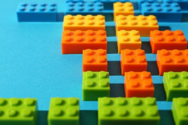 İnşaat oyuncağı. Açık mavi arkaplanda renkli tuğlalar, yakın plan