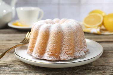 Tahta masaya pudra şekerli lezzetli limonlu pasta, yakın plan.