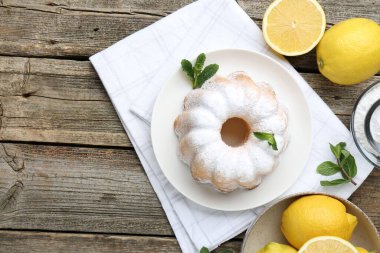 Lezzetli limonlu pasta pudra şekeri, taze meyve ve ahşap masa üzerinde nane şekeri, düz yatak. Metin için boşluk