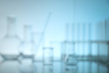 Ayna yüzeyinde açık mavi arkaplana karşı laboratuvar camının bulanık görüntüsü