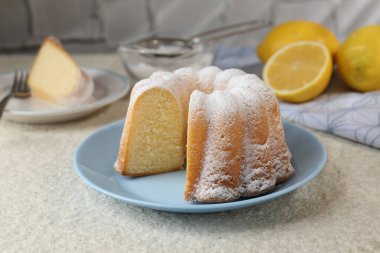 Açık dokulu masaya pudra şekerli lezzetli limonlu pasta, yakın plan.