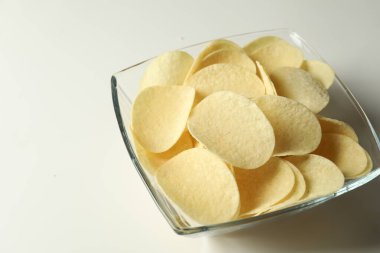 Beyaz arka planda lezzetli patates cipsi, yakın plan.