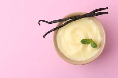 Lezzetli vanilyalı puding, nane ve kapsüller pembe arka planda, üst manzara. Metin için boşluk