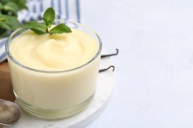 Lezzetli vanilyalı puding ve nane şekeri beyaz masada, yakın plan. Metin için boşluk