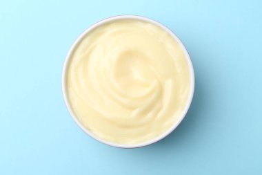 Açık mavi arkaplanda leziz vanilyalı puding.