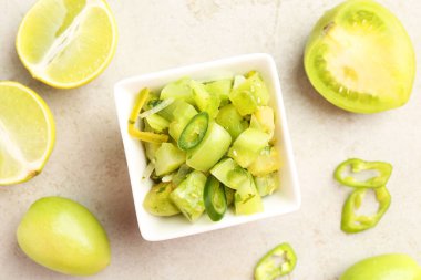 Lezzetli salsa (Pico de gallo) kasede ve hafif desenli masa üzerinde ürünler, düz yatıyordu.