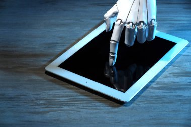 Yapay zeka. Ahşap masada tablet kullanan robot el, yakın plan.