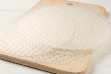 Beyaz ahşap masadaki yenilebilir kağıt çarşaflar, yakın plan.