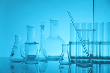 Ayna yüzeyinde açık mavi arkaplana karşı laboratuvar camları