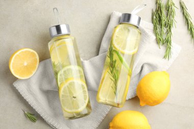 Limonlu limonlu limon suyu, biberiye ve taze meyveler gri masada, düz yatıyordu.