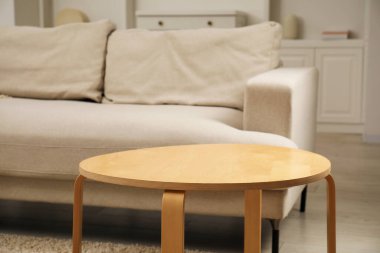 Oturma odasındaki kanepenin yanındaki ahşap sehpa çok şık.