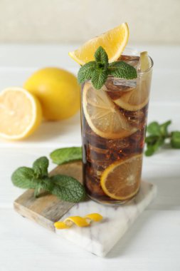 Limon dilimli taze buzlu kola ve beyaz ahşap masada nane şekeri. Yakın plan.