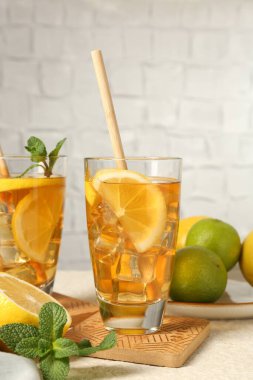 Pipet, nane, limon ve limon ile buzlu çayı yeşil arka planda dokuma masasında tazeliyorum.