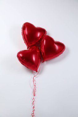 Işık arka planında kalp şeklinde kırmızı balonlar, üst manzara. Sevgililer Günü