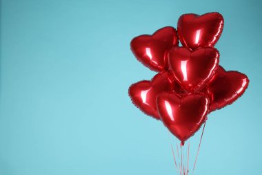 Açık mavi arka planda bir sürü kırmızı kalp şeklinde balon, yazı için boşluk. Sevgililer Günün kutlu olsun.