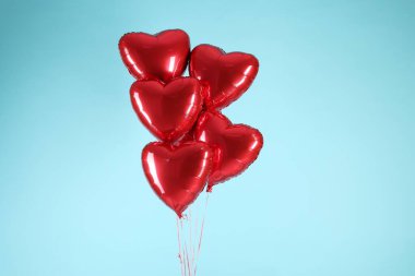 Açık mavi arka planda bir sürü kırmızı kalp şeklinde balon. Sevgililer Günün kutlu olsun.