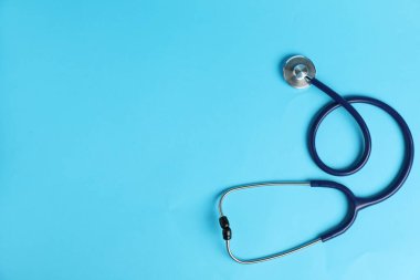 Açık mavi arka planda steteskop, üst manzara. Metin için boşluk
