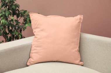 Kanepede, pastel kahverengi duvarın yanında, yakın plan.