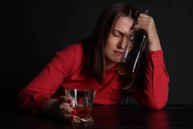 Alkol bağımlılığı. Karanlıkta viski içen sefil kadın.