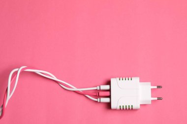 Pembe arka planda şarj kabloları olan USB güç adaptörü, üst görüş. Metin için boşluk