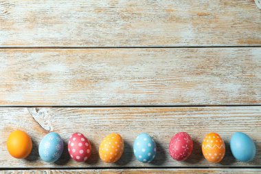 Süslü Paskalya yumurtaları açık ahşap masada, düz yerde. Metin için boşluk