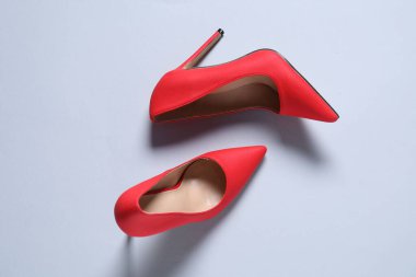 Beyaz arka planda kırmızı yüksek topuklu ayakkabılar.