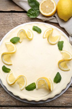 Lezzetli limonlu cheesecake. Nane ve taze meyveli. Tahta masada, düz uzanmış.