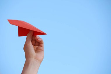 El yapımı kağıt uçakla açık havada gökyüzüne karşı duran kadın, yakın plan. Metin için boşluk