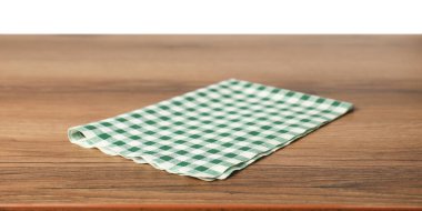 Beyaz arkaplana karşı ahşap masada yeşil kareli peçete